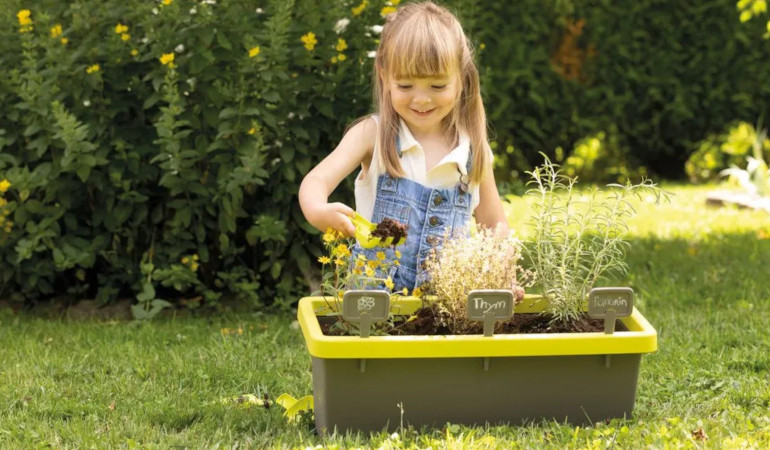 Doniczka z narzędziami i tabliczakami - Smoby dziewczynka bawiąca się w ogrodzie