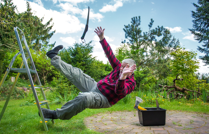 starszy mężczyzna w crocssach upada z drabiny ogrodowej