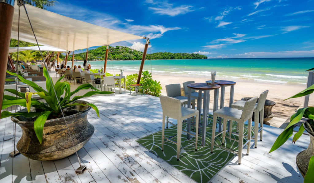 Egzotyczne miejsce, plaża z palmami, morze oraz zestaw białych mebli barowych