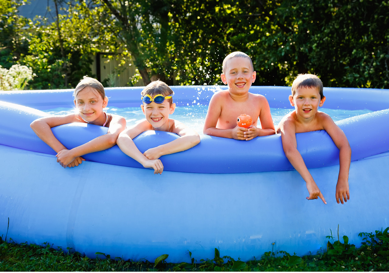 Dzieci opierające się o krawędź basenu ogrodowego