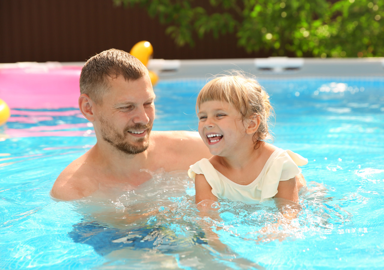 Dziewczynka z ojcem kąpią się w basenie