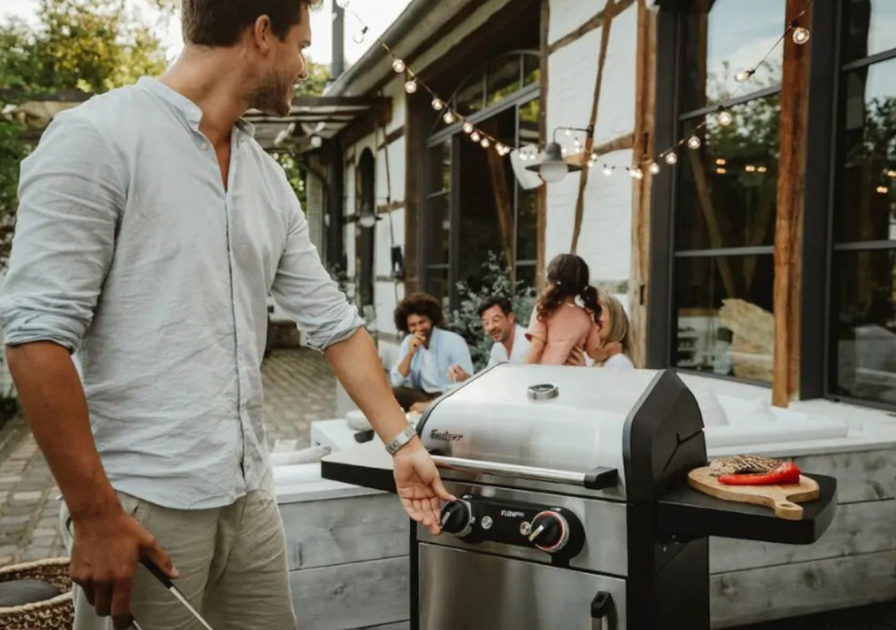 Grill elektryczny eFlow PRO 2 Turbo - ENDERS mężczyzna stoi przy zamkniętym grillu na tarasie