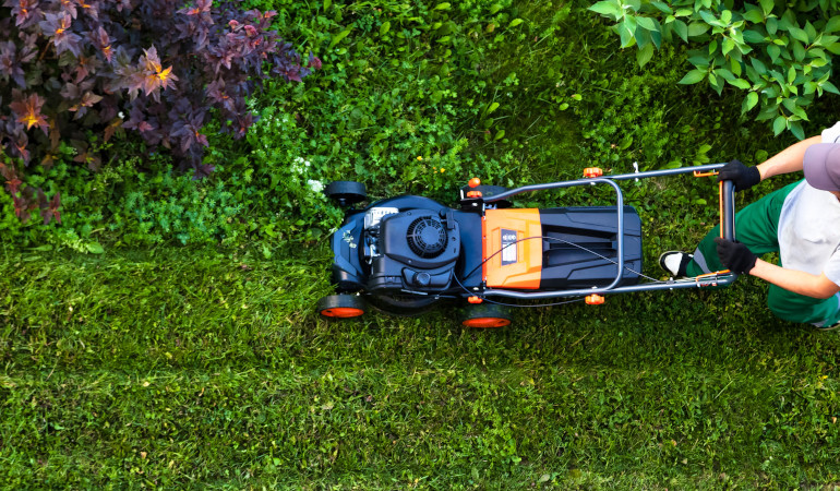 Mężczyzna kosi trawnik