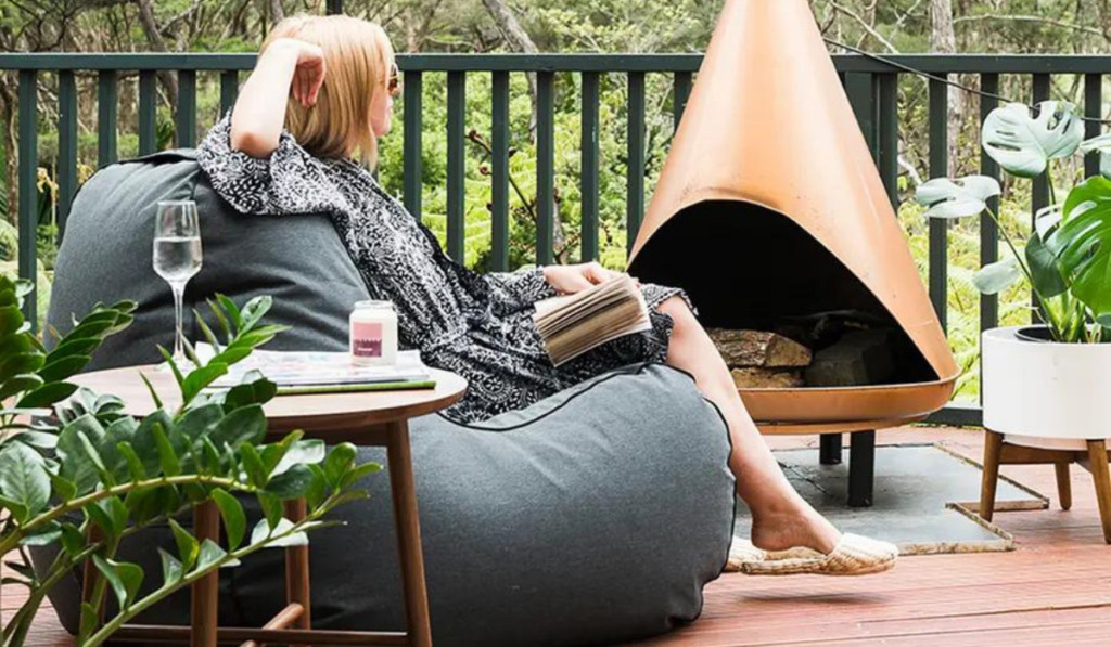 Kobieta siedzi na worku do siedzenia na tarasie