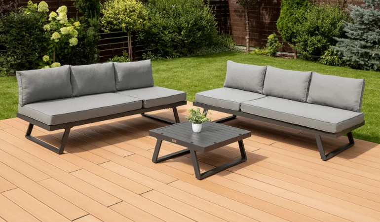 Narożnik modułowy MIDWAY Dark Grey - FOCUS GARDEN na tarasie ogrodowym otoczony zielenią, narożnik jest w kolorze szarym w zestawie ze stolikiem