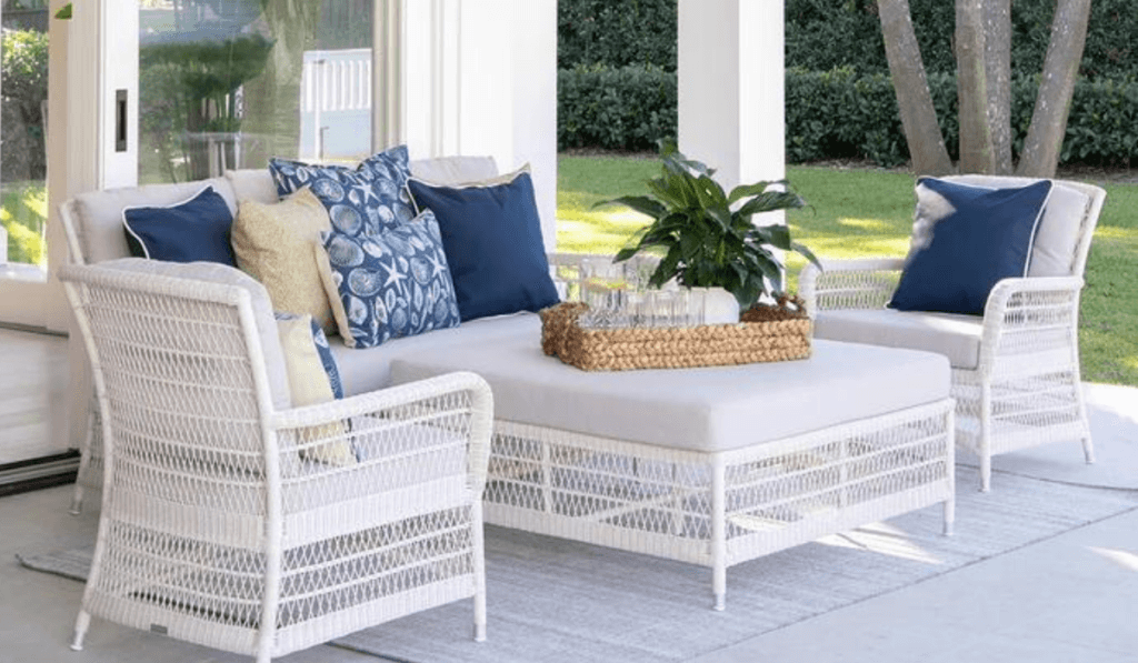 Zestaw białych mebli w stylu rustykalnym/boho wraz z poduszkami w kolorze niebieskim oraz koszem na białym stoliku