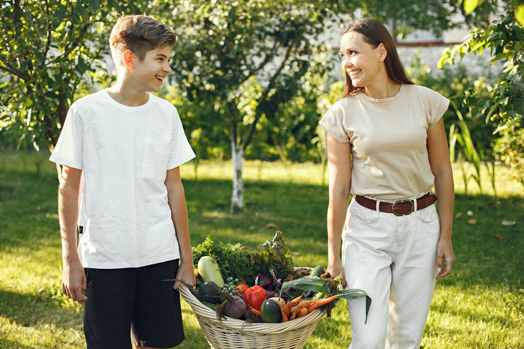 Syn i matka niosą skrzynię z warzywami