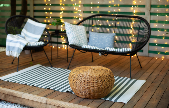 meble ogrodowe pod wiatą z dodaatkami typu poduszki, koce, narzyty i nastrojowe oświelenie