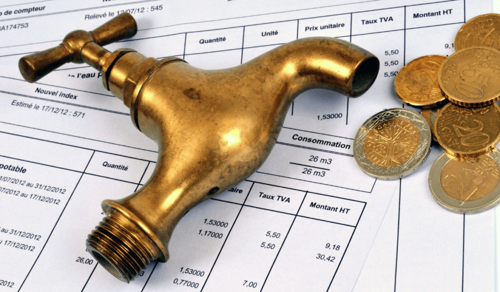 miedziany kran, obok leżą monety a pod przedmiotami rachunki za wodę